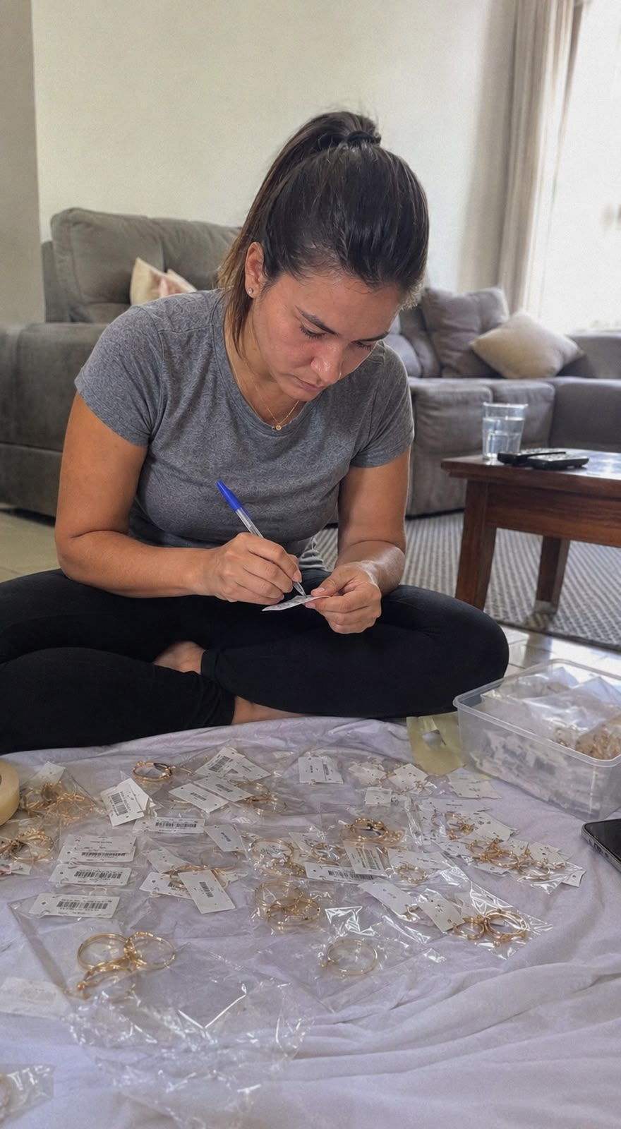 Empreendedora sentada no chão precificando peças de semijoia